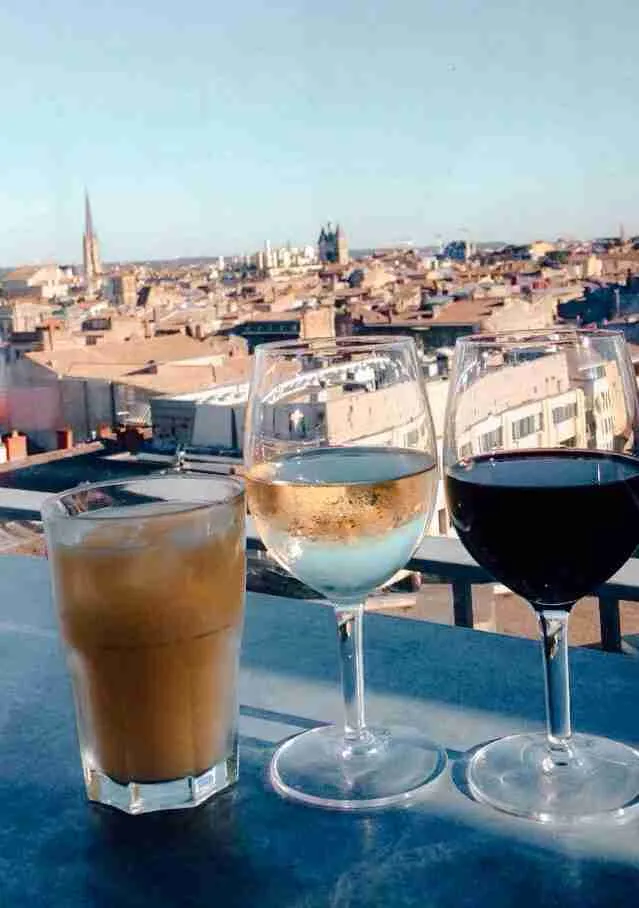 3 drinks sitting on a bar overlooking the city of Bordeaux 