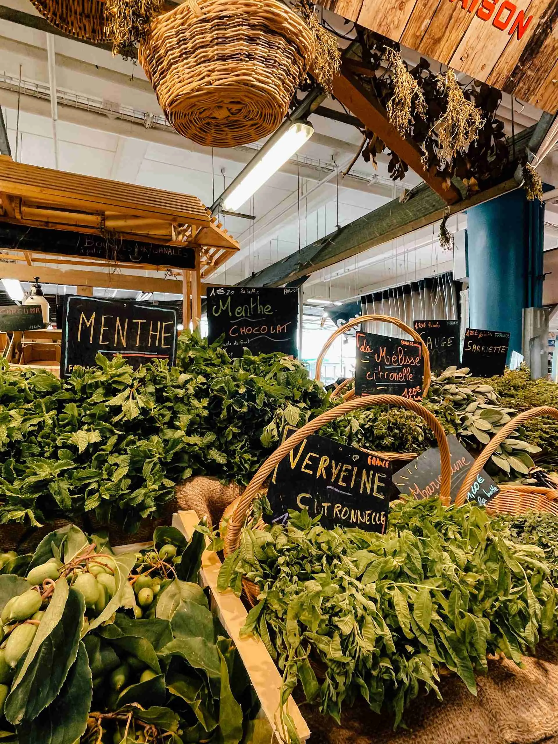 Bunches of herbs such as different variations of mint in baskets in the Marché des Capucines 