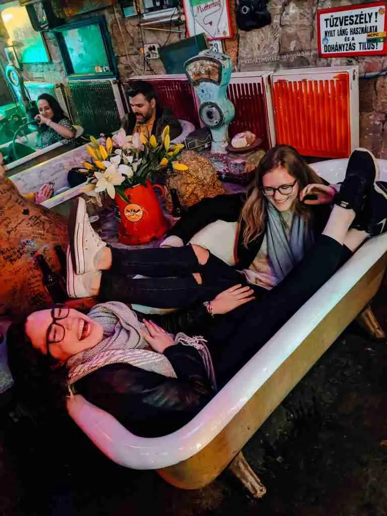 2 girls laughing in a bathtub in the Budapest Ruin Bars