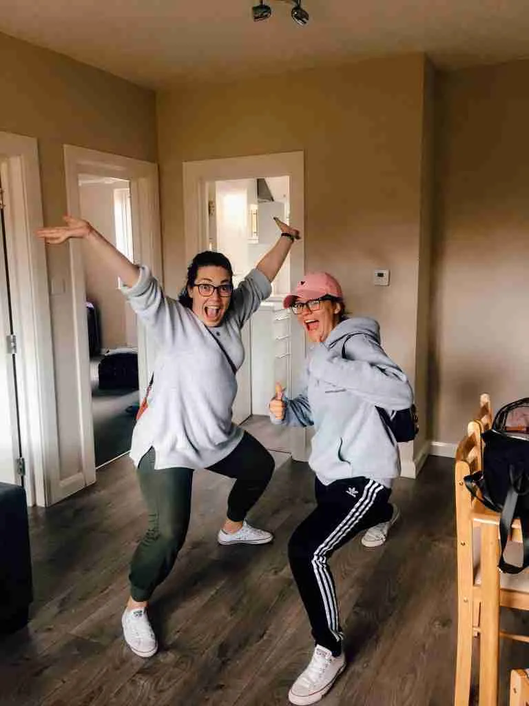 2 girls posing in a living room celebrating!