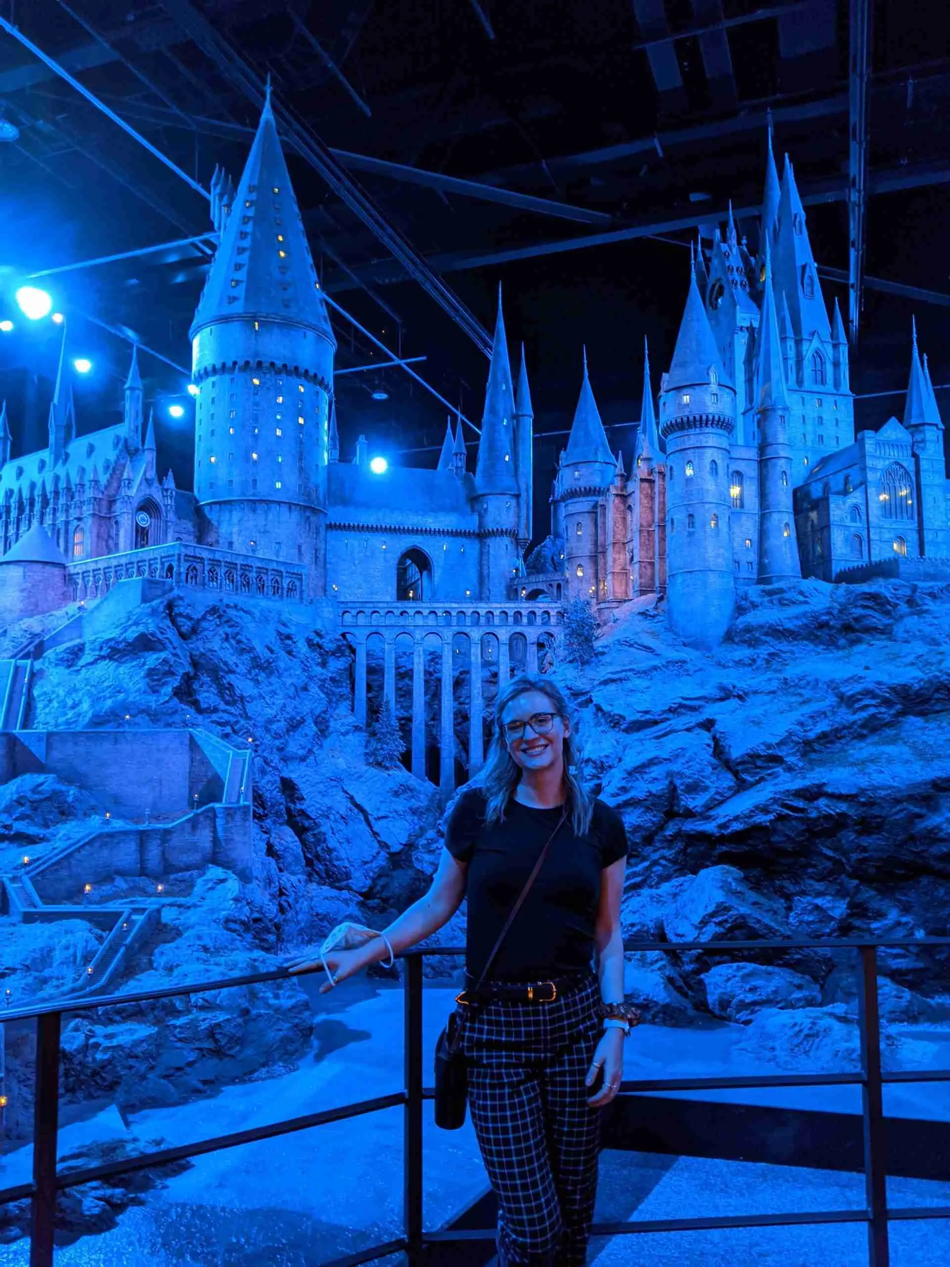 a girl standing in front of Hogwarts castle inside the Harry Potter Studio Tour - one of the most popular day trips from London