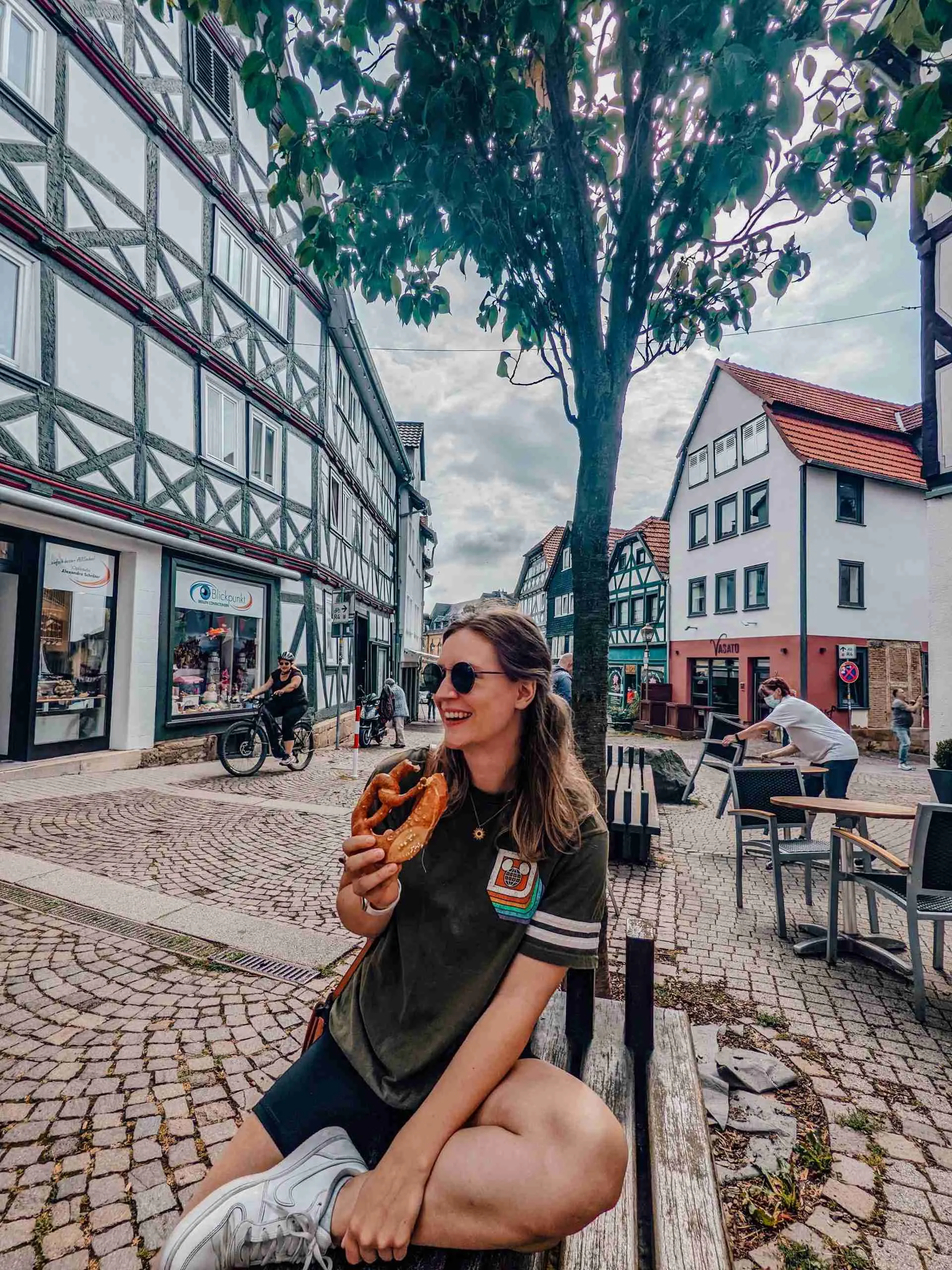 a girl enjoying a pretzel in Schiltach - a perfect snack fitting for our road trip budget