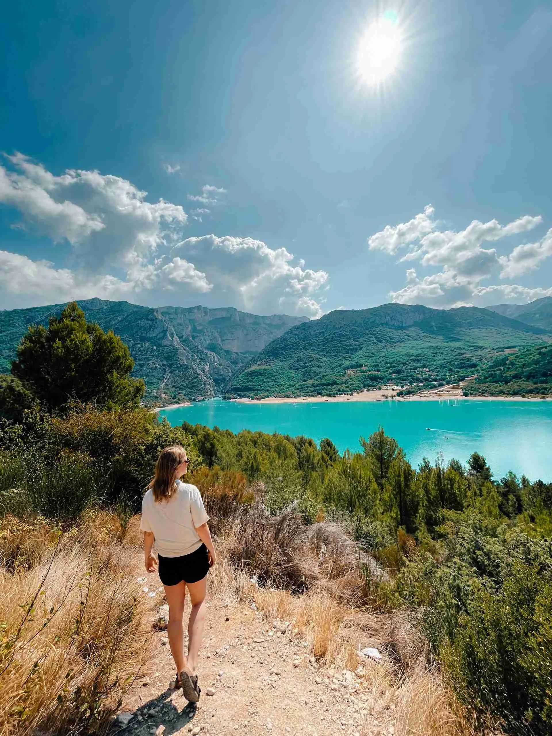 A girl is walking and admiring the view overlooking the lake beside the Gorges du Verdon 