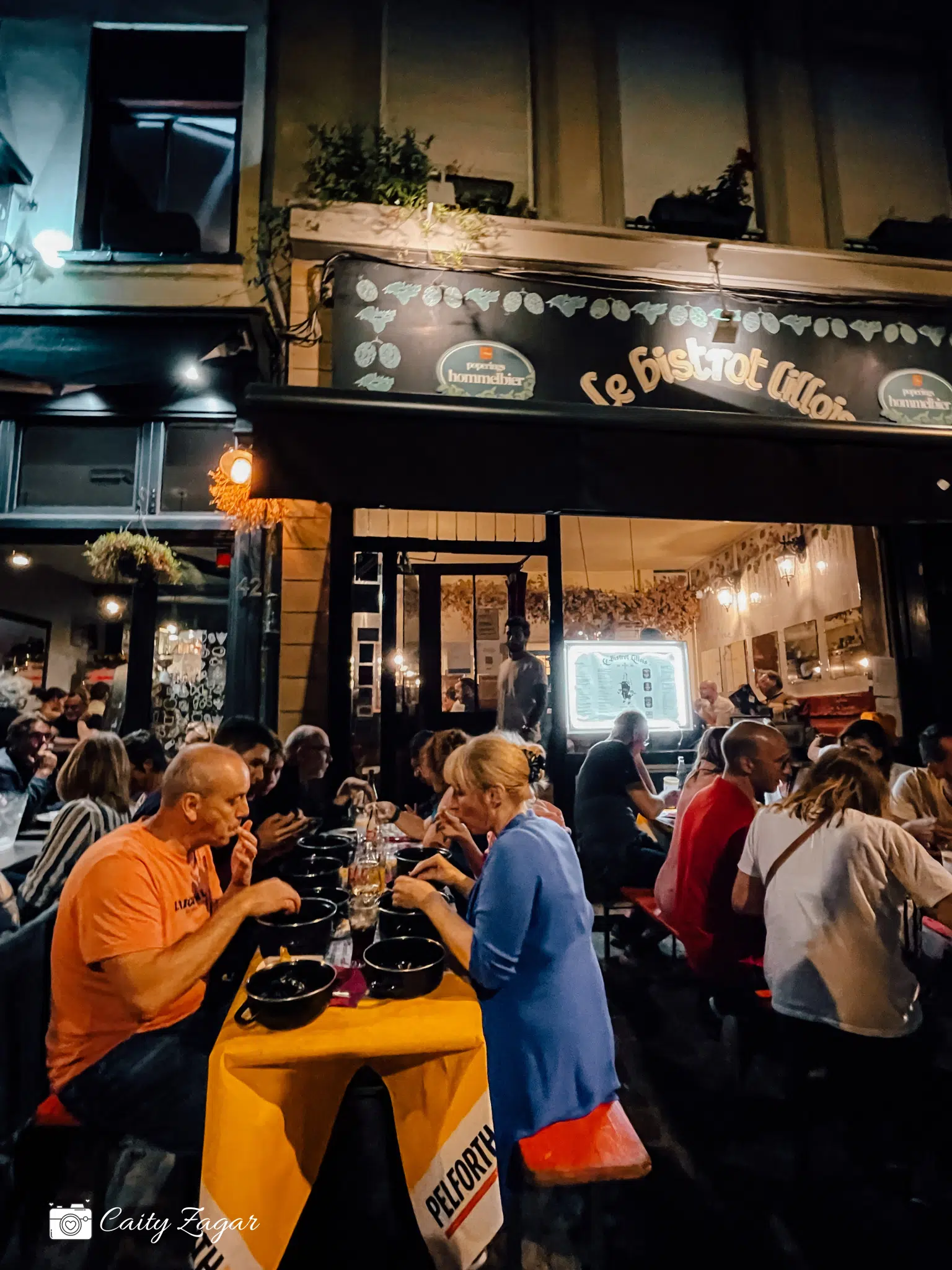 People enjoying their moules frites in the late night hours of Braderie