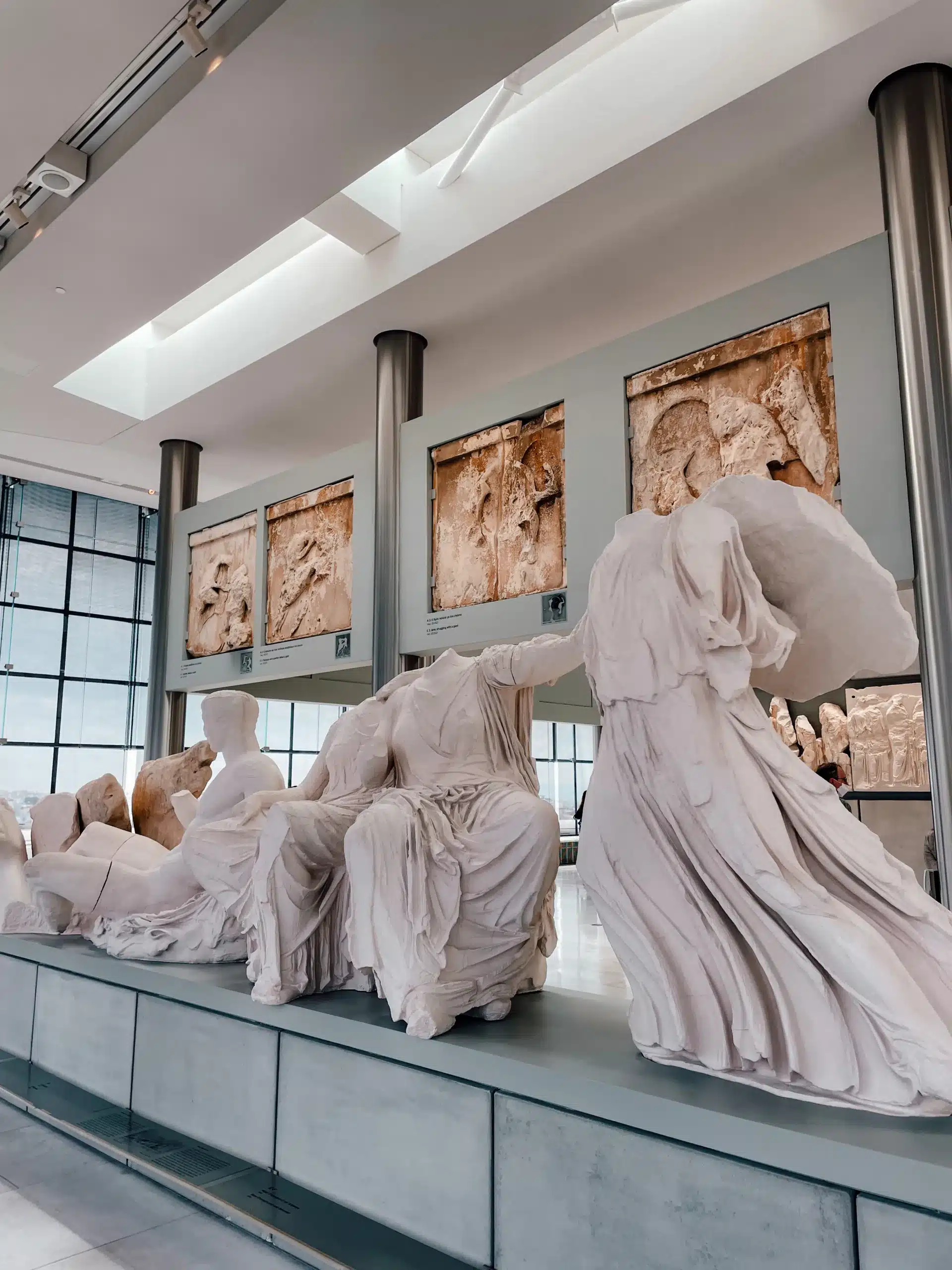 Several stone statues, original relics from the Acropolis, sit inside the Acropolis Museum in Athens 