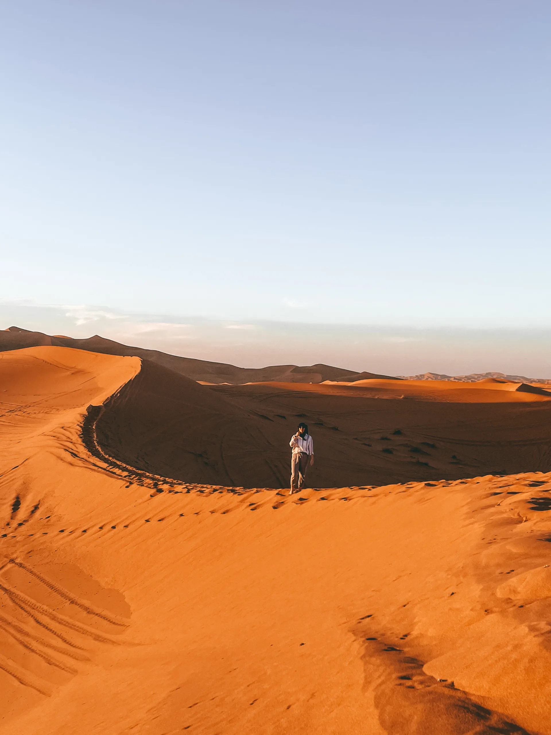 Someone in the distance standing on a desert dune in the Sahara