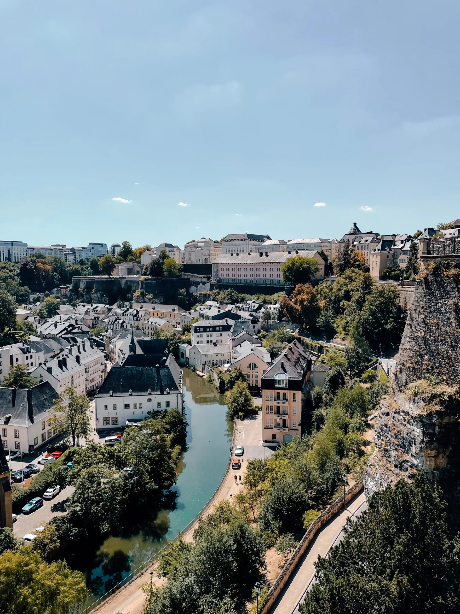 View overlooking the Lower City of Luxembourg from the Chemin de la Corniche with a small river winding through historic homes and buildings