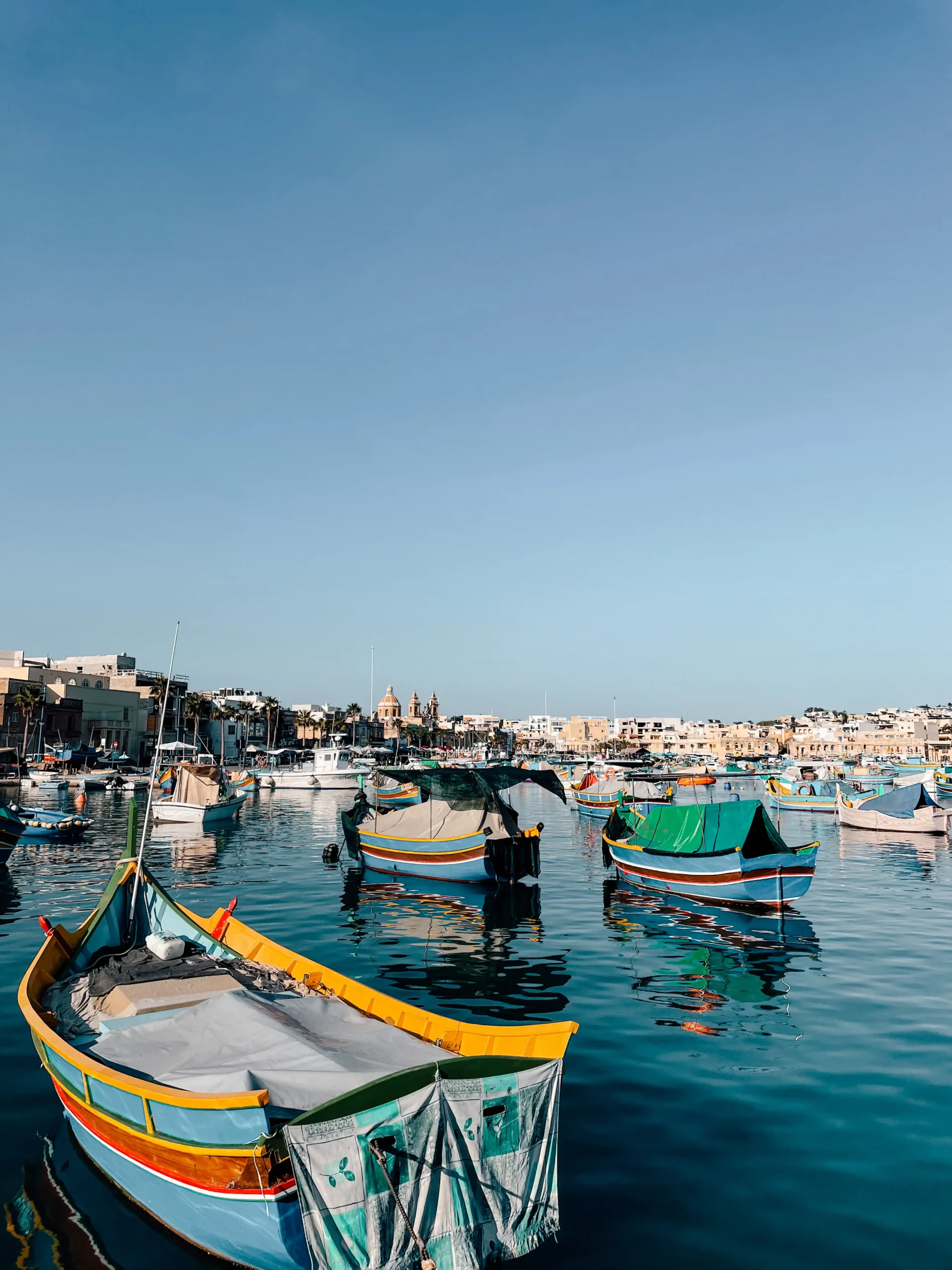 Marsaxlokk fishing village with the colorful traditional boats sitting in the bay 